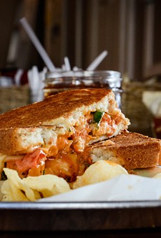 A chipotle chicken sandwich — Italian bread, muenster cheese, pulled chicken, tomatoes, fresh basil, and chipotle sauce — from Cheese Masters on Park Avenue.