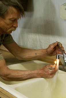 A homeowner tries to light his tap water on fire in a scene from the first Gasland film.