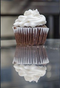 A vanilla cupcake with chocolate frosting (left), vegan chocolate cupcake with white frosting (middle), and mini vanilla cupcakes (right) from Get Caked in Village Gate.