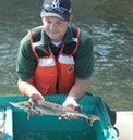 DEC staffer Dan Mulhall holds up a 2-year-old sturgeon. - PHOTO BY JEREMY MOULE