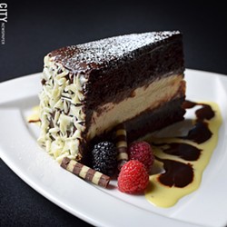 Chocolate Broadway cake with layers of chocolate cake, ganache, and vanilla cheesecake from Tournedos Steakhouse. - PHOTO BY MATT DETURCK