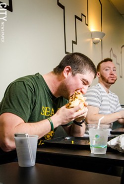 Dan Vadnais (right) has completed the burrito challenge in 14 minutes 40 seconds. Here he attempts a 3-pound cupcake challenge at Burrito Fresca. - PHOTO BY MARK CHAMBERLIN