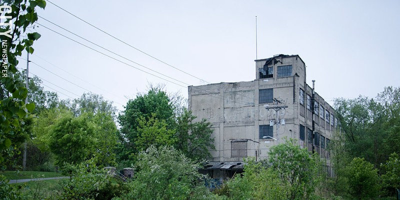 A vacant, dilapidated building at the end of Flint Street marks the Vacuum Oil site.