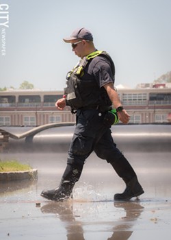 An emergency worker walks through flood waters. - PHOTO BY RYAN WILLIAMSON