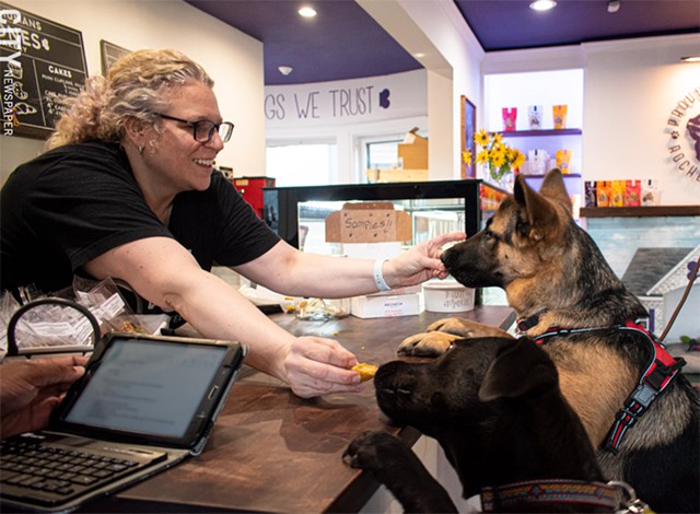 Bones Bakery owner Dani Lawson treats Cooper and Penny to pooch-friendly pumpkin muffins. - PHOTO BY JACOB WALSH