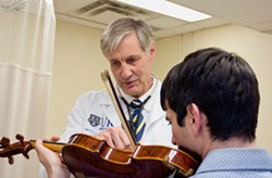 Dr. Ralph Manchester of Eastman Performing Arts Medicine works with a violinist. - PHOTO COURTESY OF THE UNIVERSITY OF ROCHESTER MEDICAL CENTER