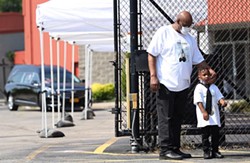 David Gantt’s brother, Freddie Gantt hugs his grandson Dwight Abraham, while standing outside the Church of Love Faith Center where friends and family paid respects to the late lawmaker. - PHOTO BY MAX SCHULTE