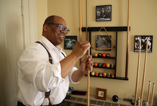 Van White chalks a pool cue as he prepares to break on the table that Martin Luther King Jr. played on as a student at Crozer Theological Seminary. White had the table restored and placed in his law office. - PHOTO BY MAX SCHULTE