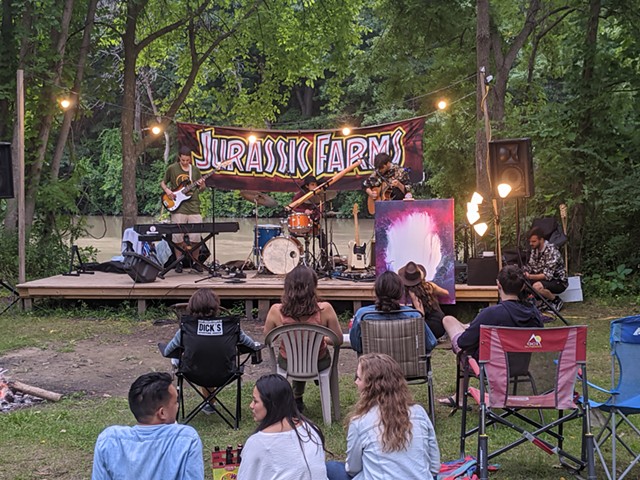 Pop-folk band Head to the Roots performs as Casey Arthur paints live in the foreground at Jurassic Farms. - PHOTO BY DANIEL J. KUSHNER