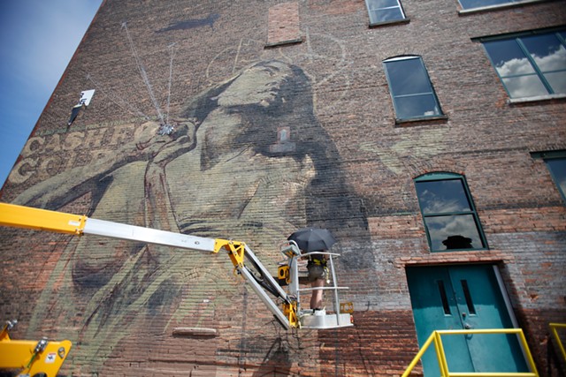 South African artist Faith47 paints "Rhapsody" on the Lofts at Michaels-Stern on Pleasant Street in 2012. - FILE PHOTO