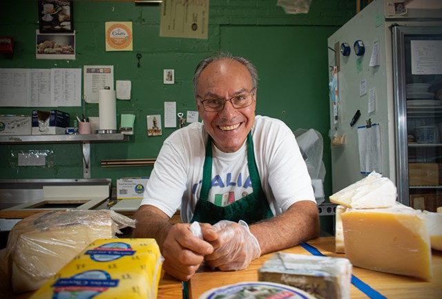 Vincenzo Giordano at the cheese counter of VM Giordano Imports Inc., which he opened in the Rochester Public Market nearly 30 years ago. - PHOTO BY JACOB WALSH