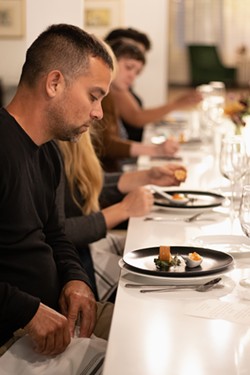 Guests prepare to dig into the appetizer course that featured king salmon and diced apple paired with cauliflower custard and salmon roe. - PHOTO BY QUAJAY DONNELL