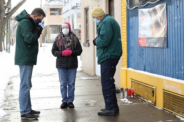 From left to right, Ed Knauf, Donna Ecker, and John Crego pray outside Gold More Mini Mart on Jan. 7, 2022, five days after 14-year-old Julius Greer Jr. was shot to death in front of the store. - PHOTO BY MAX SCHULTE
