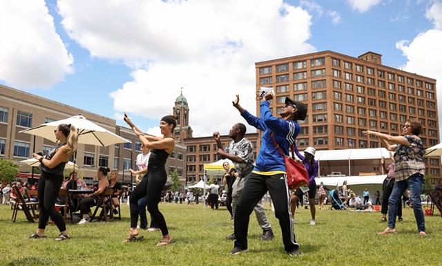 Parcel 5 was the site of the "Midday Bash," part of the Rochester Downtown Development Corp.'s "Downtown Definitely" campaign to draw people to the city's center with food trucks, music, lawn games, and fitness instructors. - PHOTO BY MAX SCHULTE