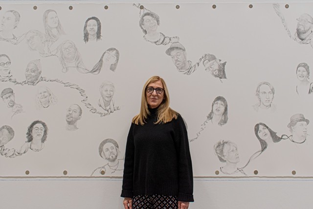 Susan Begy stands in front of her mural "Entanglement" at Rochester Contemporary Art Center. - PHOTO BY JACOB WALSH