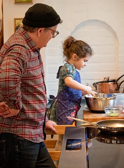 Ada mixes ingredients for an omelet while dad stands ready with the skillet. - PHOTO BY JACOB WALSH