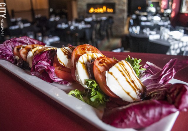 Heirloom Tomato Salad with fresh mozzarella, spring lettuces, radicchio, and a garlic-balsamic reduction. - PHOTO BY RENÉE HEININGER