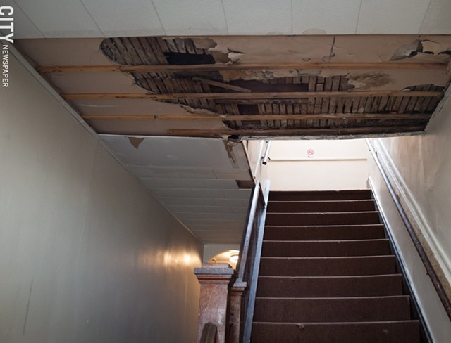 A ceiling falling apart in the the 967 Chili Avenue apartment building entrance way. - PHOTO BY JAKE CLAPP