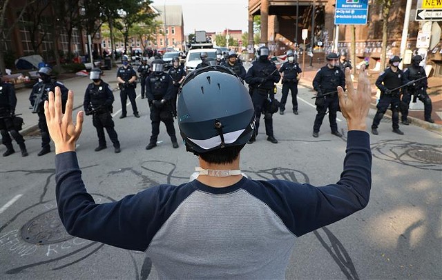 A protester faces off with a line of police at City Hall on  Sept. 16, 2020.