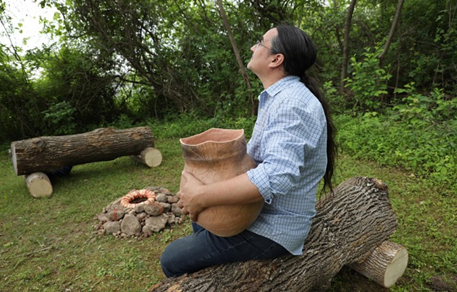Mike Jones, a Native American artist, holds a clay pot he made for the Earth Altar project. His work, along with other altars, can be seen at the Ganondagan State Historic Site in Victor.
