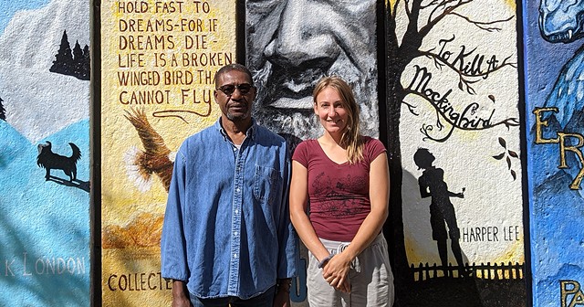 Artists Richmond Futch Jr. and Chloe Smith in front of the completed book spine mural at Arnett Branch Library.