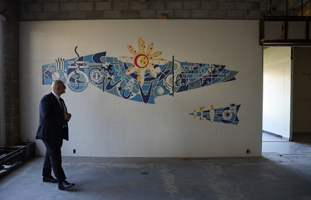Derek Dlugosh-Ostap, the chief executive of Delta-X Global, inspects a mosaic that was unearthed from behind a wall at a former Kodak research building that he is having rehabilitated.