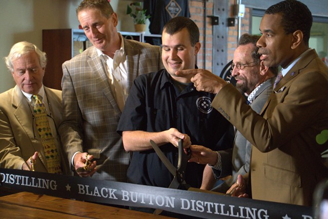 From left, Visit Rochester President and CEO Don Jeffries, Greater Rochester Chamber of Commerce CEO Bob Duffy, Black Button Distilling owner and master distiller Jason Barrett, Assemblyman Harry Bronson, and Mayor Malik Evans cut the ribbon on the distillery's new space on University Avenue.