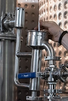 Master Distiller Jeff Fairbrother tests fresh spirits from the still at Black Button Distilling.