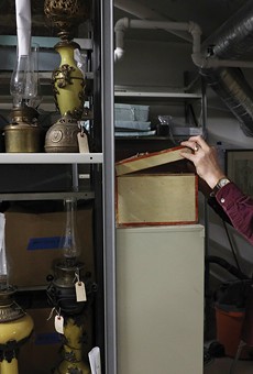 Rochester Historical Society archivist Bill Keeler examines a handmade tackle box that once belonged to Seth Green. Green was pioneer in fish farming and established the first fish hatchery in the United States.