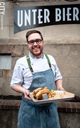 PHOTO BY RYAN WILLIAMSON - Unter Biergarten Chef and owner Derrick DePorter holds the Knackwurst.