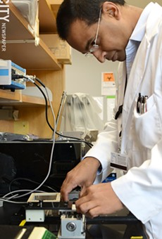 URMC researcher Sam Daynwansa works on a machine that stretches cells to promote their growth. PHOTO BY MATT DETURCK