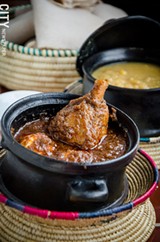 PHOTO BY MARK CHAMBERLIN - Yedoro wat (a drumstick in barbecue sauce with a hard-boiled egg) served with kik alitcha (yellow split peas with onion, herbs, and spices) and injera, from Taste of Ethiopia on State Street.